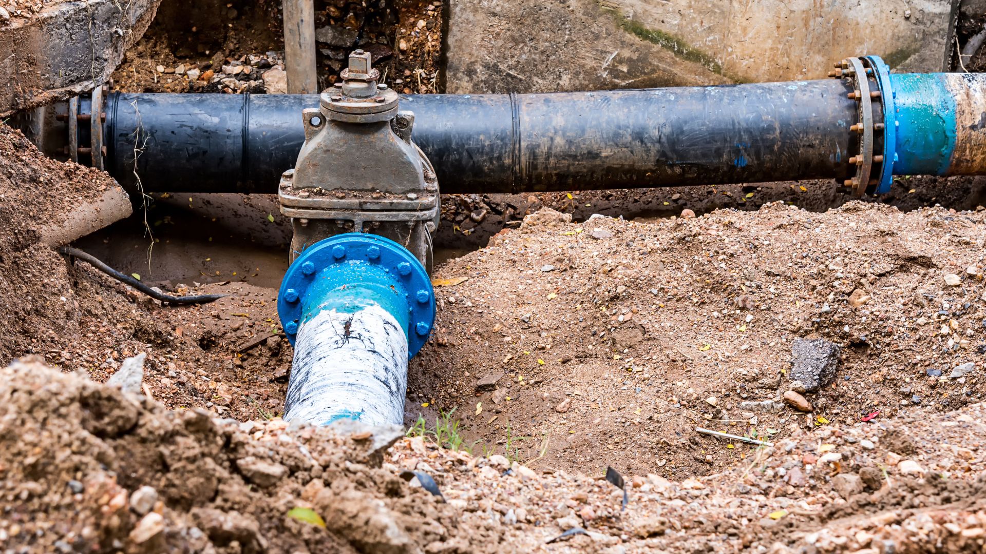 A blue pipe laying on top of a pile of dirt