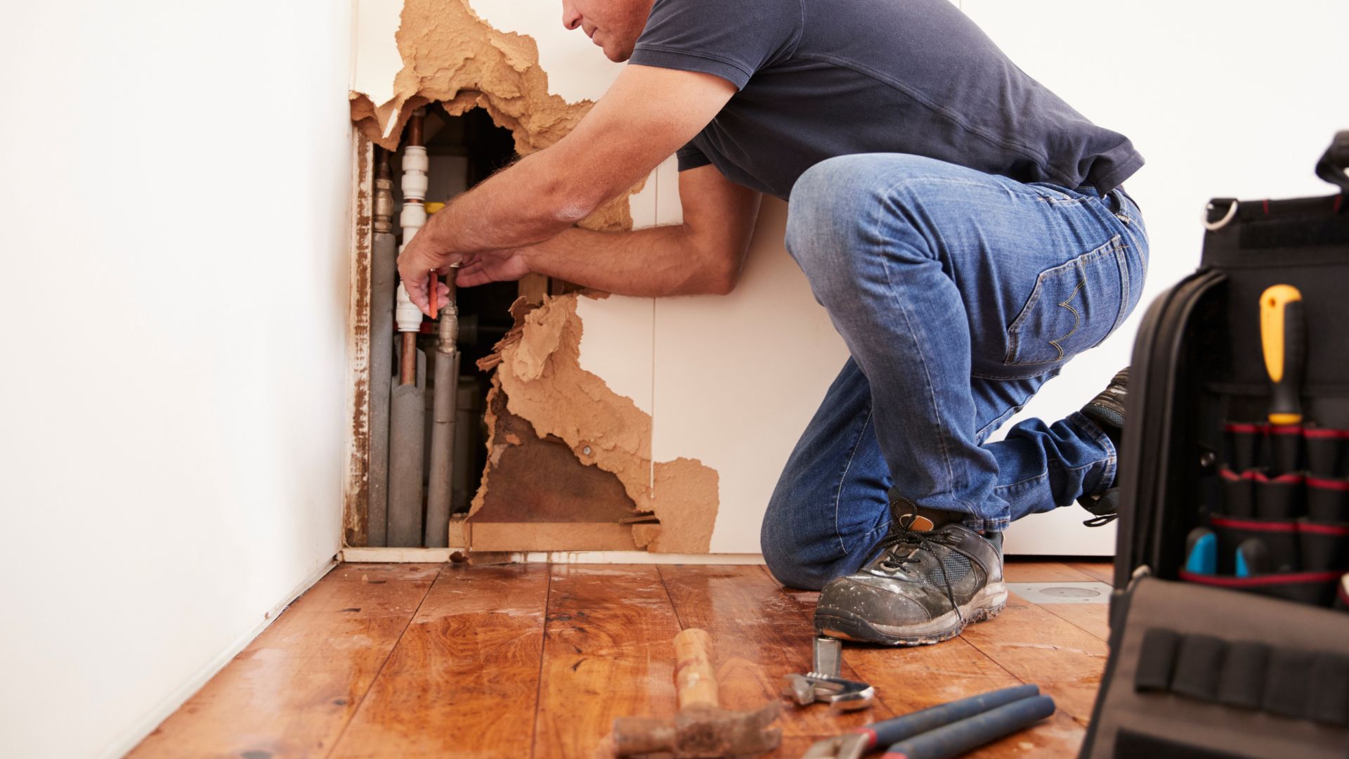 A man working on a hole in a wall