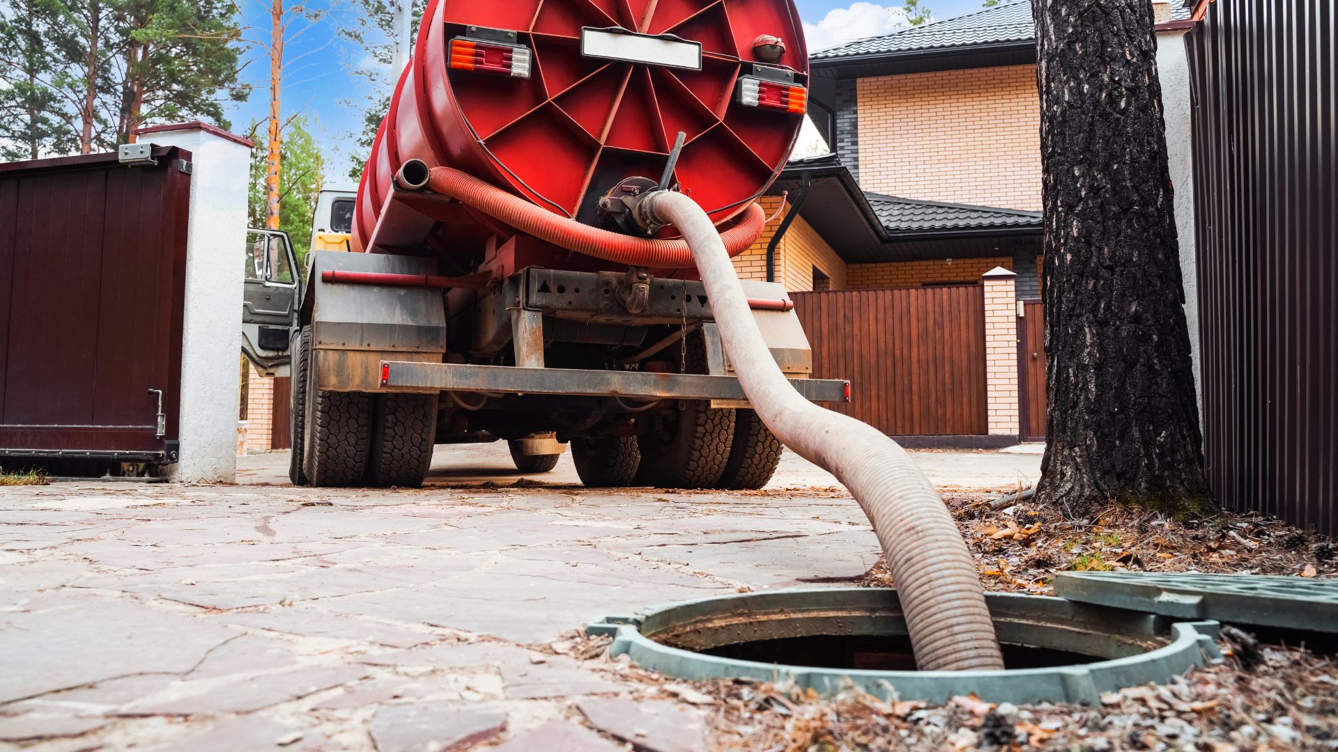 A large red truck with a hose attached to it