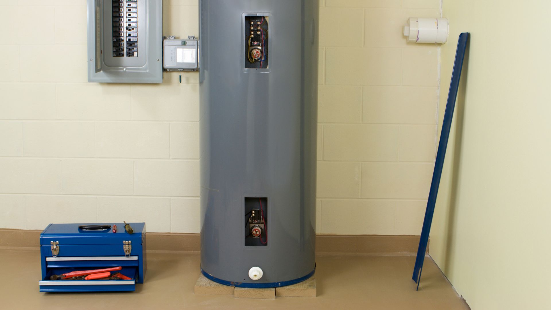 A water heater sitting in a room next to a wall